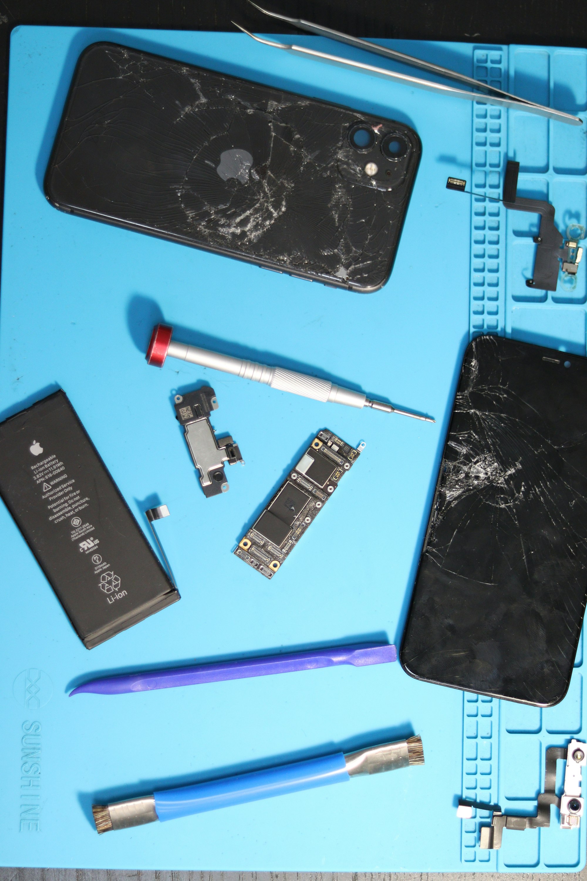 Telefoner på værkstedsbakke. Stockfoto fra Unsplash — ikke fra denne butik.